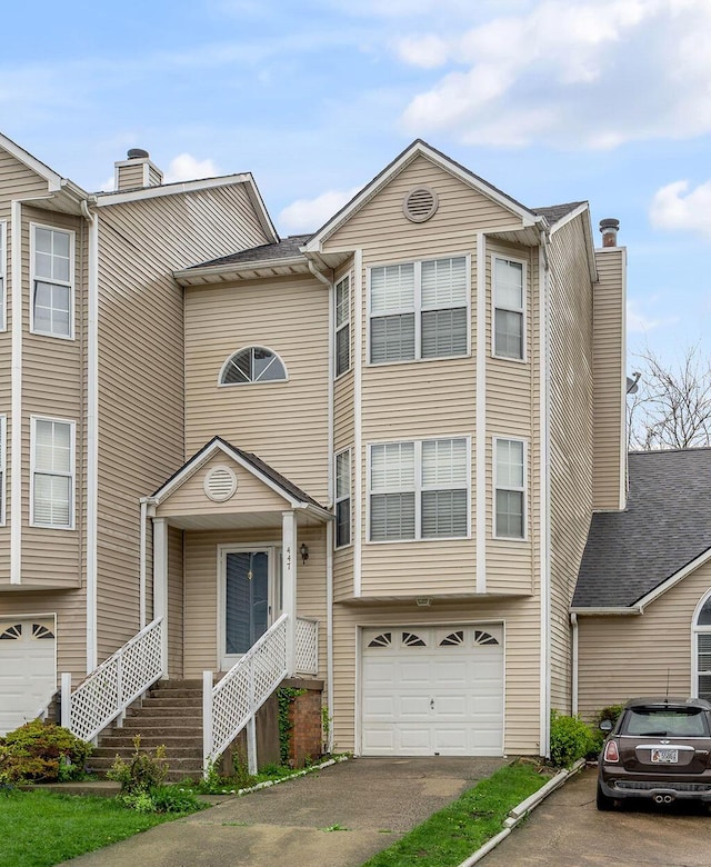 townhome / multi-family property with a garage, aphalt driveway, and a chimney