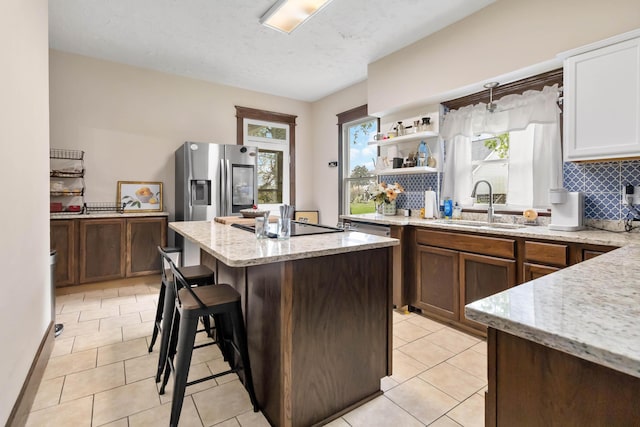 309 W Columbia St, Somerset, KY 42501 - kitchen featuring tasteful backsplash, light tile patterned floors, a sink, a kitchen island, and light stone counters