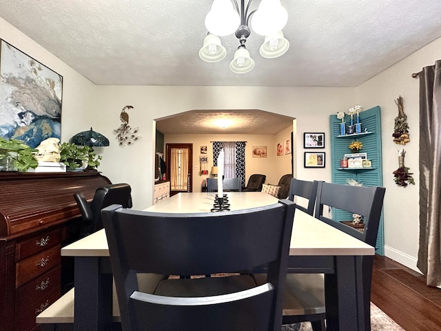 3473 Grundy Rd, Somerset, KY 42501 - dining room featuring a chandelier, arched walkways, wood finished floors, a textured ceiling, and baseboards