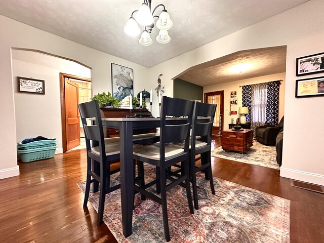 3473 Grundy Rd, Somerset, KY 42501 - dining room with arched walkways, wood finished floors, a chandelier, baseboards, and a textured ceiling