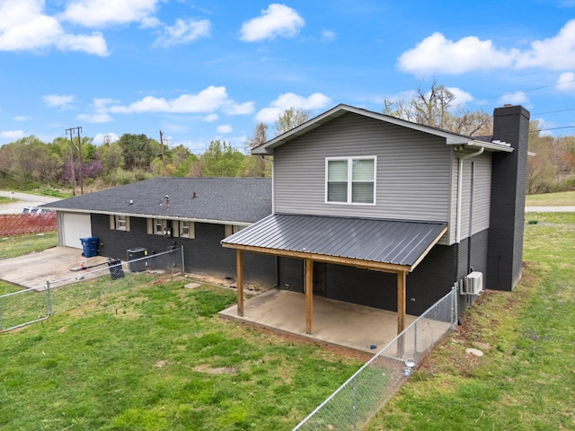 back of house featuring a patio area, a yard, a garage, a chimney, and fence
