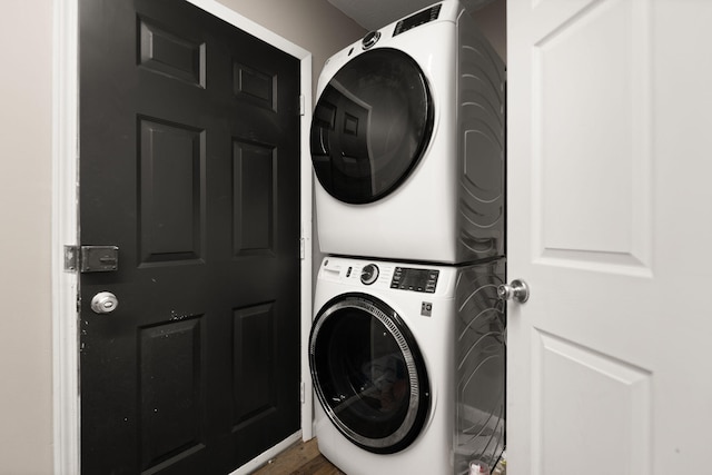 clothes washing area with stacked washer / dryer