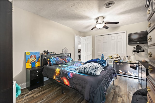 bedroom with ceiling fan, a textured ceiling, a closet, visible vents, and wood finished floors