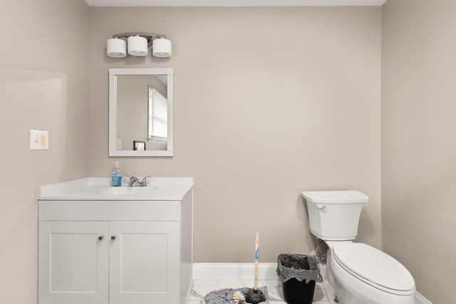 bathroom with marble finish floor, vanity, baseboards, and toilet