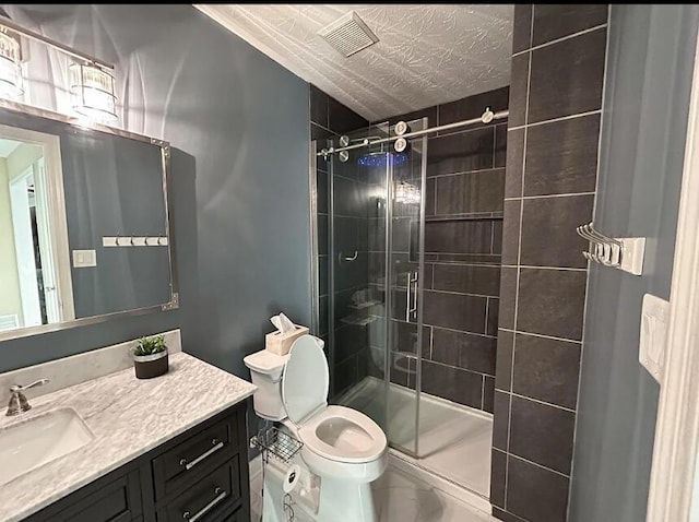 bathroom featuring vanity, visible vents, a shower stall, and toilet