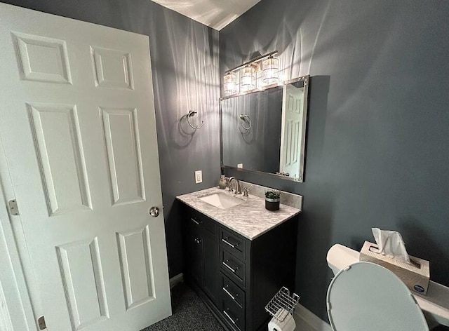 half bathroom with baseboards, toilet, and vanity