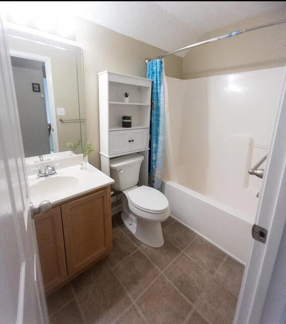 full bathroom featuring shower / bath combination with curtain, toilet, vanity, and tile patterned floors