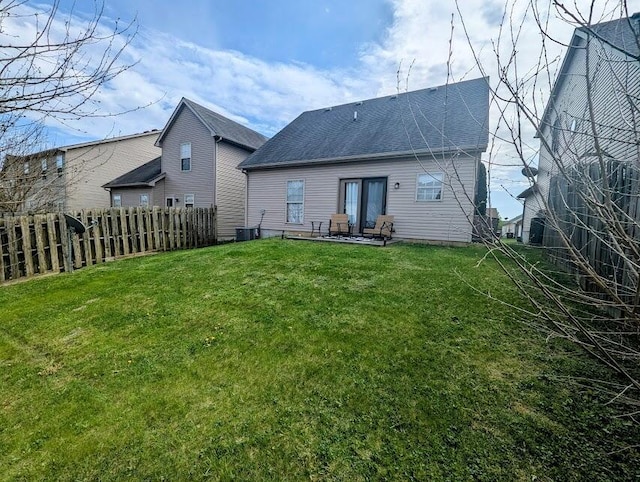 back of property with a lawn, fence, a patio area, and a shingled roof