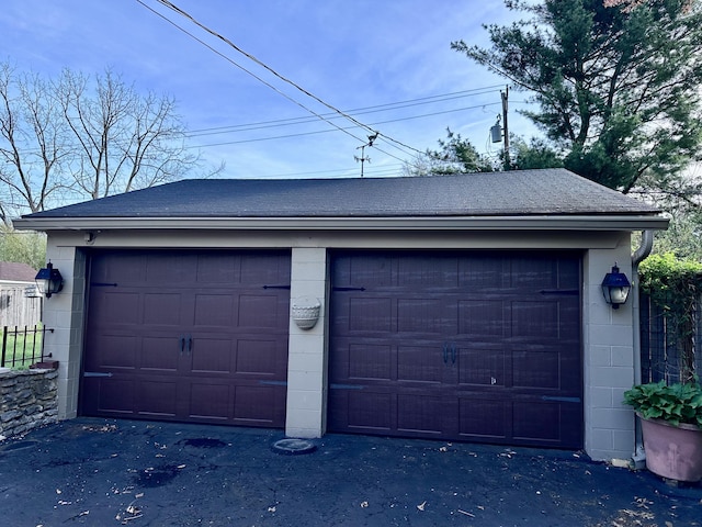 detached garage featuring fence