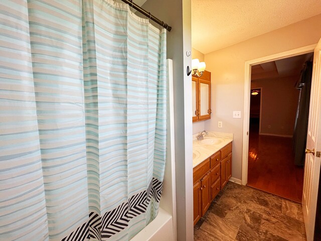 305 Saddle Wood Ct, Berea, KY 40403 - full bathroom with baseboards, a textured ceiling, double vanity, and a sink