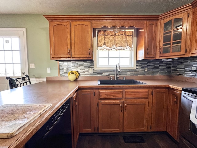 305 Saddle Wood Ct, Berea, KY 40403 - kitchen with a sink, black dishwasher, a peninsula, brown cabinetry, and backsplash