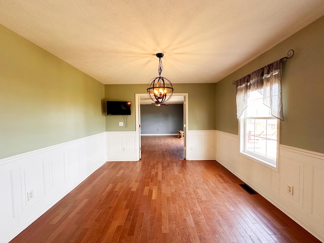 305 Saddle Wood Ct, Berea, KY 40403 - unfurnished dining area with visible vents, wood finished floors, a notable chandelier, and wainscoting