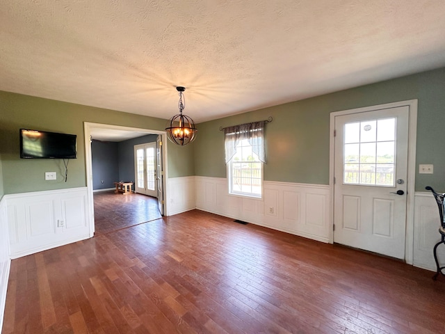 305 Saddle Wood Ct, Berea, KY 40403 - unfurnished dining area with a chandelier, wainscoting, dark wood-style flooring, visible vents, and a textured ceiling