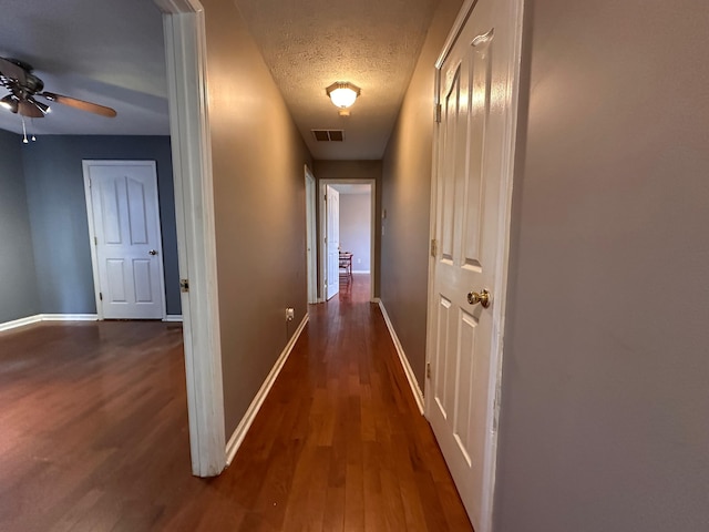 305 Saddle Wood Ct, Berea, KY 40403 - hallway featuring dark wood-style floors, a textured ceiling, visible vents, and baseboards