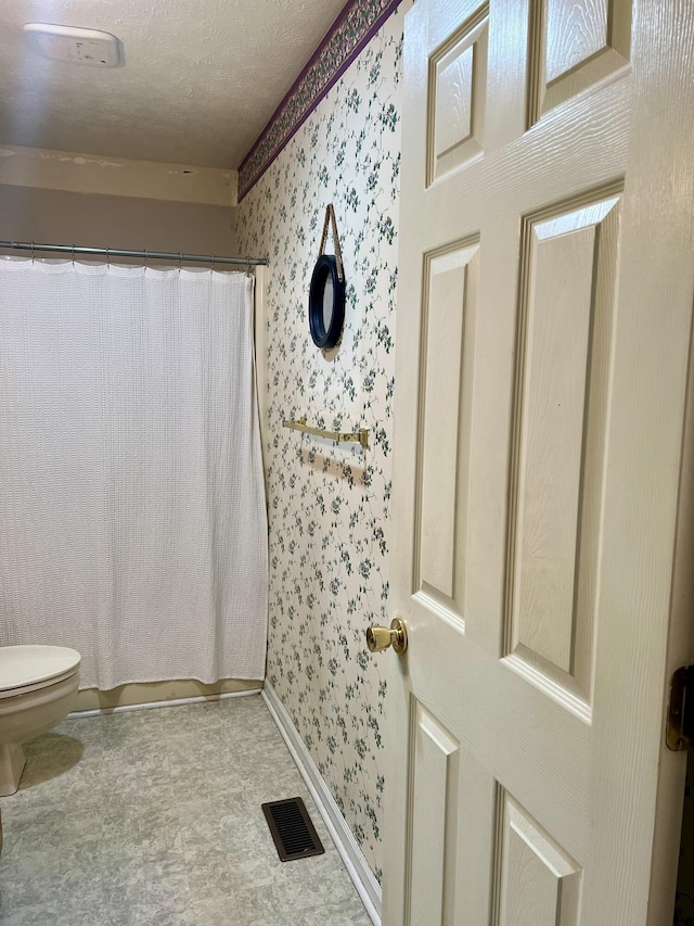 111 Keystone Dr, Richmond, KY 40475 - full bathroom featuring a shower with shower curtain, wallpapered walls, a textured ceiling, toilet, and visible vents