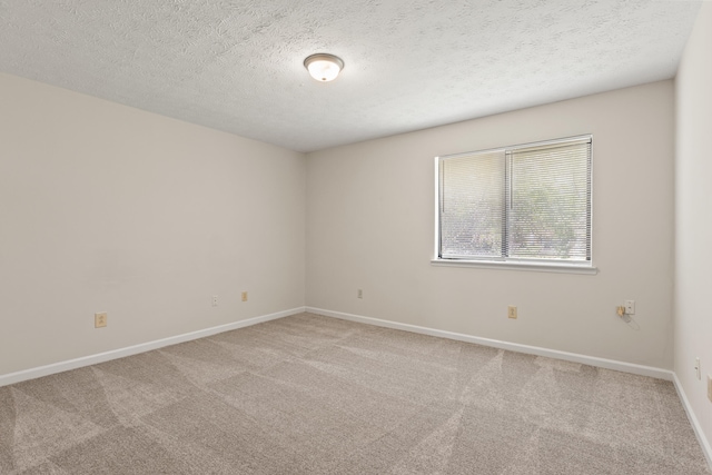unfurnished room featuring a textured ceiling, baseboards, and carpet