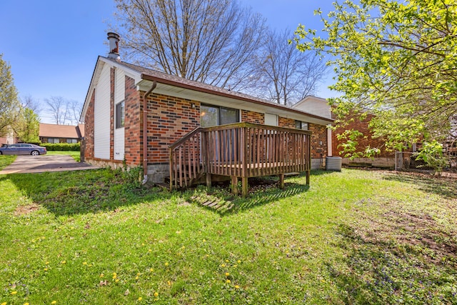 back of house featuring a yard, a wooden deck, and brick siding
