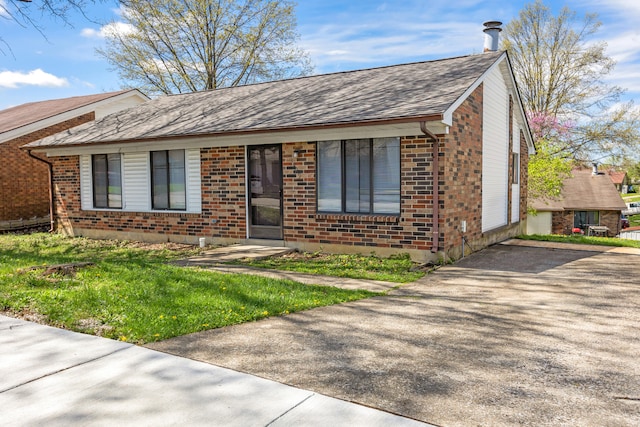 single story home featuring roof with shingles, driveway, and brick siding