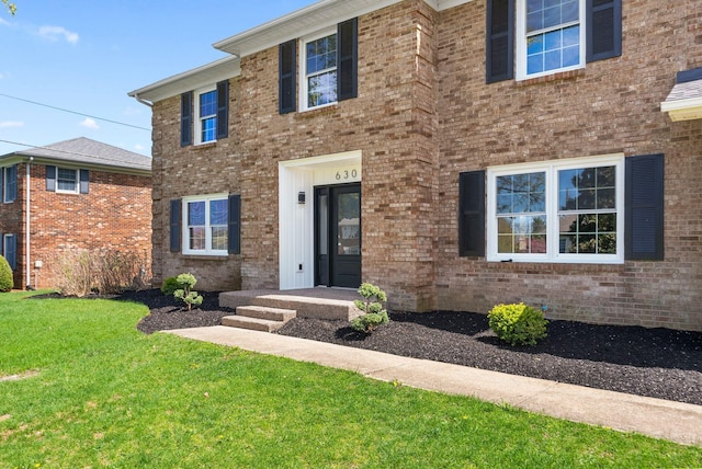 view of front of property featuring a front yard and brick siding