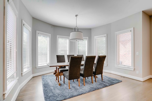 dining room with baseboards and light wood-type flooring