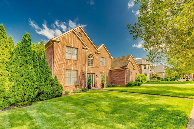view of front of property with a front yard and brick siding