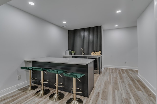 bar with recessed lighting, light wood-type flooring, baseboards, and wine cooler