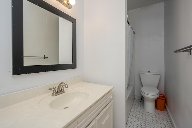 bathroom with tile patterned flooring, vanity, baseboards, and toilet