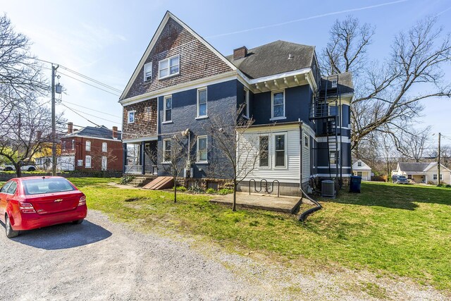 view of front of home featuring a front yard, stairway, and central air condition unit