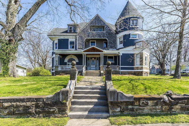 victorian-style house featuring a porch and a front lawn