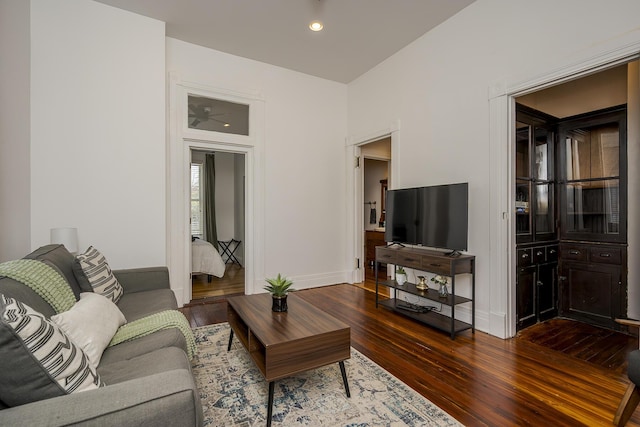 living room featuring dark wood-style flooring, baseboards, and recessed lighting