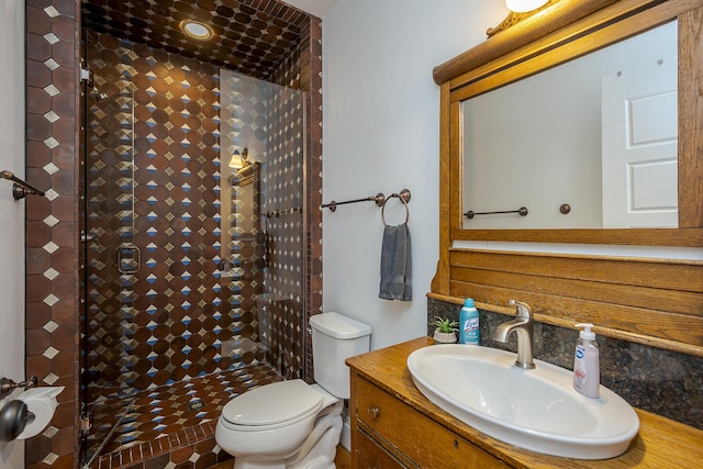 bathroom with a shower stall, vanity, and toilet