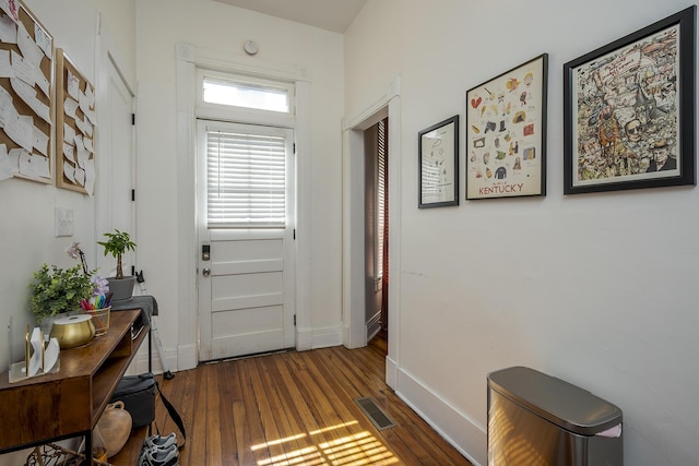 doorway to outside featuring wood finished floors, baseboards, and visible vents