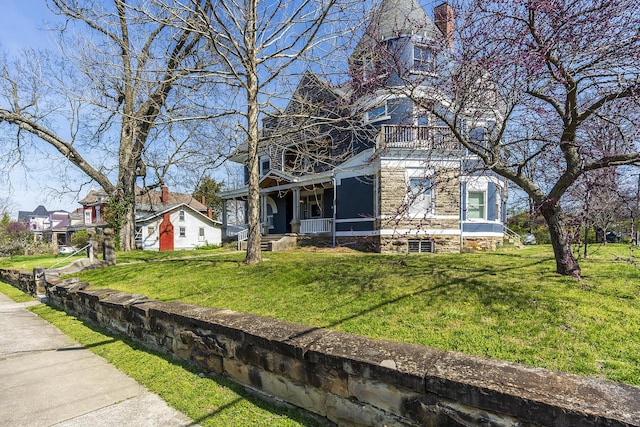 view of home's exterior with a porch, a chimney, and a lawn