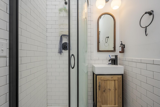 bathroom featuring tile walls, a shower stall, and vanity
