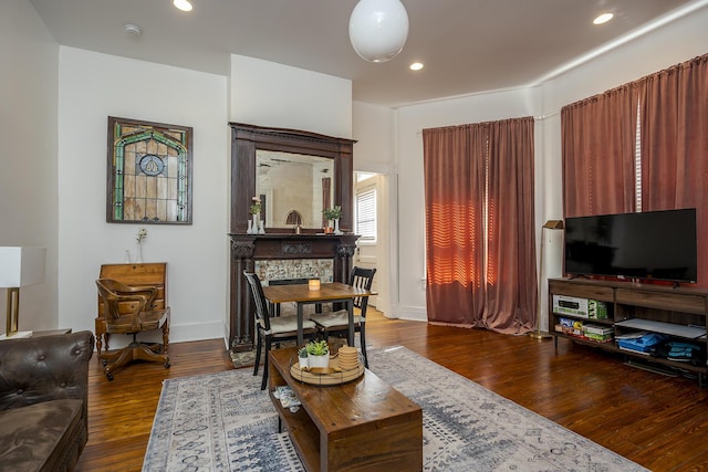 living area featuring dark wood-type flooring, baseboards, and recessed lighting