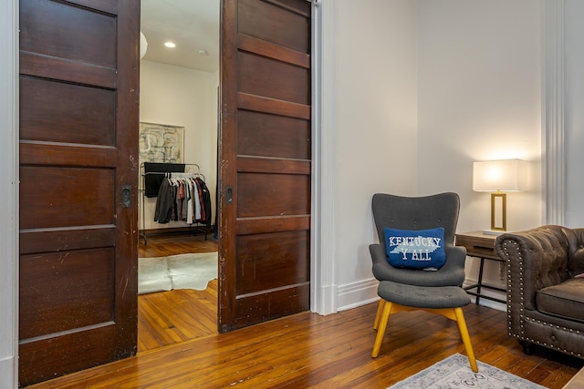 sitting room with wood-type flooring and baseboards