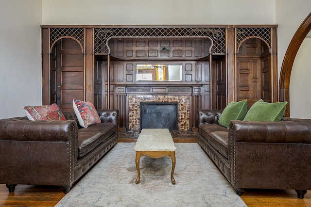 living area with a brick fireplace and wood finished floors