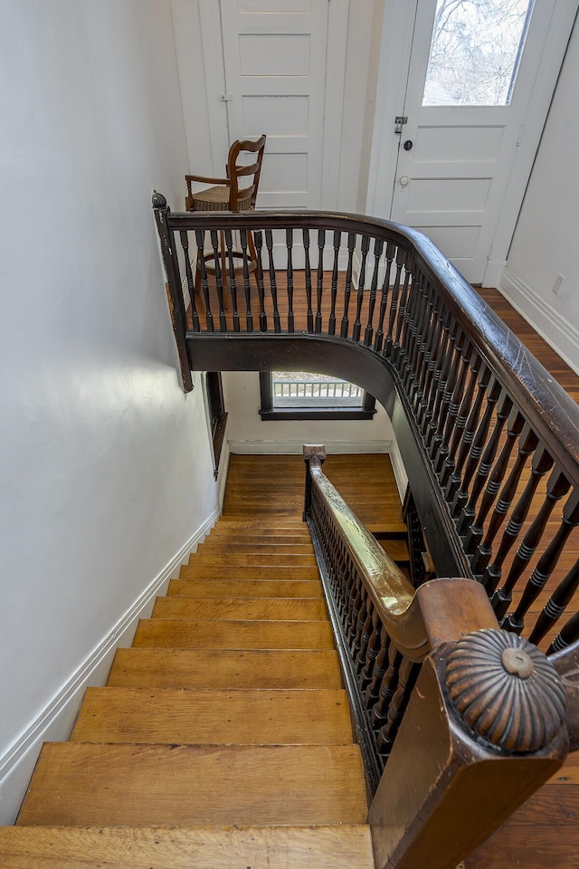 stairway with wood finished floors and baseboards
