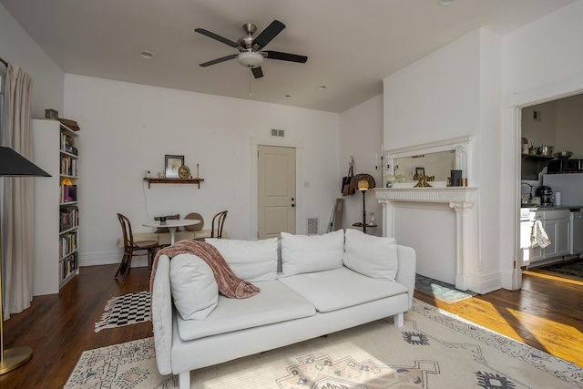 living area featuring visible vents, ceiling fan, and wood finished floors