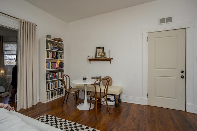 dining area featuring visible vents, hardwood / wood-style flooring, and baseboards