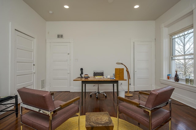 office area with visible vents, baseboards, wood finished floors, and a healthy amount of sunlight