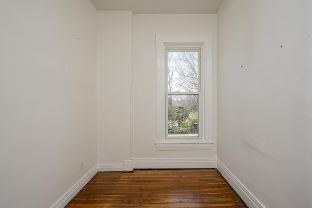 spare room with dark wood-style flooring and baseboards