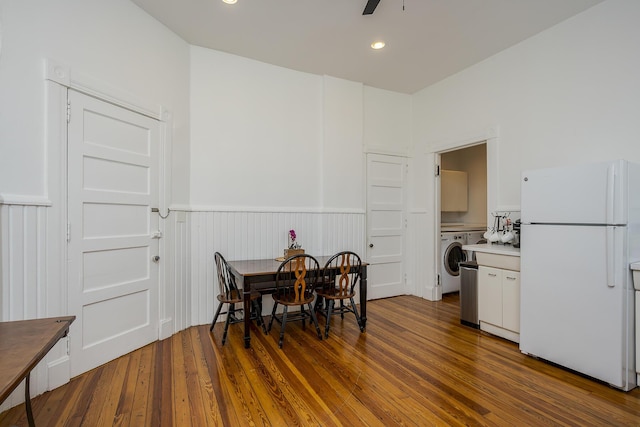 dining room featuring washer / clothes dryer, a ceiling fan, wainscoting, and wood finished floors