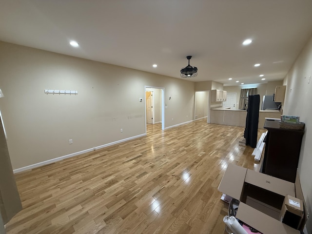 living area featuring light wood-type flooring, baseboards, and recessed lighting
