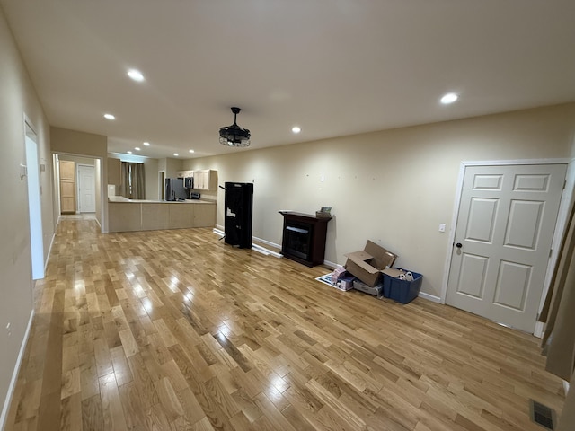 unfurnished living room with light wood finished floors, baseboards, visible vents, and recessed lighting