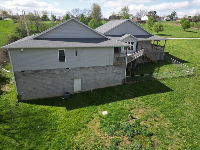back of house featuring stairs, a deck, fence, and a lawn