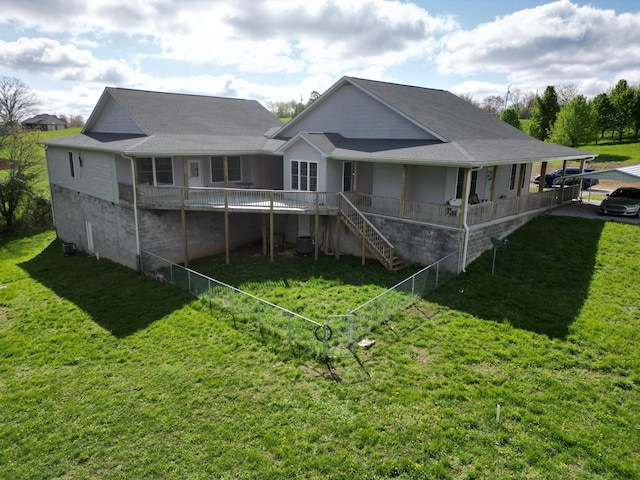 back of property with a yard and stairs