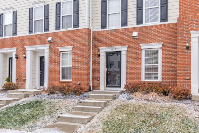 entrance to property featuring brick siding