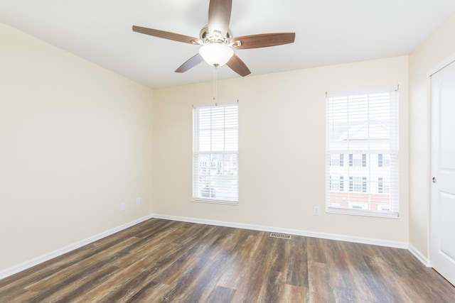 unfurnished room with dark wood-type flooring, baseboards, a ceiling fan, and visible vents