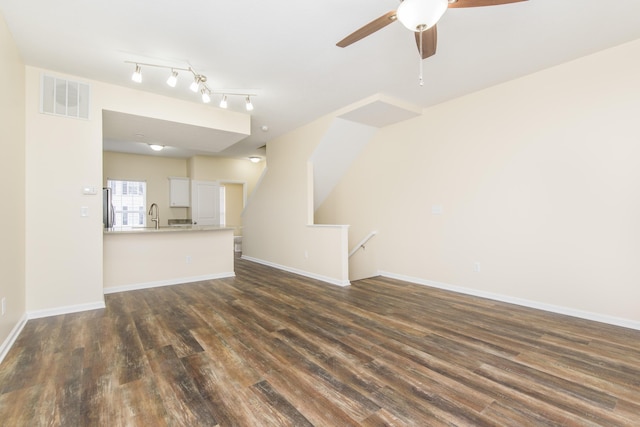 unfurnished living room with visible vents, baseboards, a sink, a ceiling fan, and dark wood finished floors